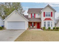 Charming two-story home featuring red accents, a well-manicured lawn, and a two-car garage at 5555 Sugar Crossing Dr, Sugar Hill, GA 30518