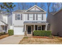 Charming two-story home featuring a well-maintained lawn, covered porch, and attached garage at 5545 Mountain Top Pl, Cumming, GA 30041