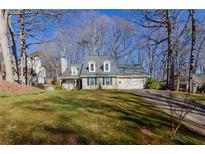 Charming home with a well-maintained lawn, integrated garage and beautiful trees surrounding the property at 1088 Raleigh Way, Lawrenceville, GA 30043