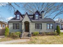 Charming two-story brick home featuring a unique architectural style, landscaped yard and inviting front entry way at 1549 Beecher Sw St, Atlanta, GA 30310