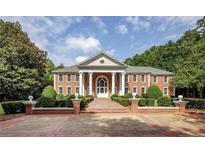 Stately brick home featuring a symmetrical design, grand columns, and manicured landscaping at 4500 Candacraig, Johns Creek, GA 30022