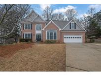 Charming two-story brick home with well-maintained lawn and a two-car garage at 5570 Saddle Tree Ct, Sugar Hill, GA 30518