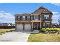 Charming brick two-story home boasts a well-manicured lawn and a two-car garage at 3815 Beaver Swamp Rd, Loganville, GA 30052