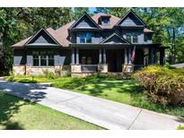 Beautiful two-story home featuring a stone facade, covered porch, and manicured lawn on a tree-filled lot at 3117 W Roxboro Ne Rd, Atlanta, GA 30324