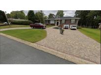 Brick home featuring a multi-vehicle driveway with landscaping and brick accents on the curb and driveway island at 3962 Chicamauga Ne Dr, Kennesaw, GA 30144