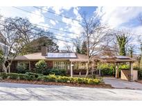 Charming single-story home with a carport, lovely landscaping, and solar panels on the roof at 630 Oakdale Ne Rd, Atlanta, GA 30307