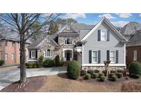 Charming two-story home with stone and gray wood facade, complemented by well-manicured landscaping at 185 Windsor Cv, Sandy Springs, GA 30328