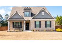 Charming brick two-story home with black shutters and well-manicured lawn and covered porch at 1809 Hanwoo Ln, Powder Springs, GA 30127