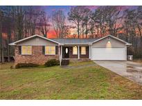 Charming single-story home with brick accents, siding, attached garage, and a well-maintained lawn at 4446 Frontier Way, Sugar Hill, GA 30518