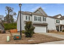 Charming two-story home with a stone facade and attached two-car garage at 9032 Jim Purcell Dr, Covington, GA 30014