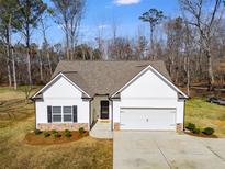 Charming home featuring white siding, a two-car garage, manicured landscaping, and a welcoming entrance at 429 Mulberry Rock Road, Temple, GA 30179