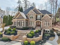 Beautiful stone and shake home with professional landscaping and front entry stair case at 11180 West Rd, Roswell, GA 30075