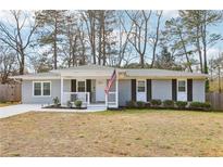 Charming single-story home featuring gray painted brick, complemented by black shutters and an inviting front porch at 456 Pretty View Se Ln, Smyrna, GA 30082