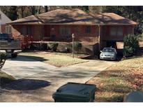 Charming brick home featuring a flat yard, driveway, carport, and inviting front porch at 1367 Pollard Sw Dr, Atlanta, GA 30311