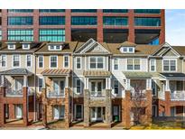 Row of townhomes with brick and stone accents beneath a modern glass and brick building at 201 16Th Nw St # 4, Atlanta, GA 30363