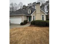 Charming one-story home with a two-car garage, beautiful lawn, and manicured shrubbery at 217 Spalding Gates Dr, Atlanta, GA 30328