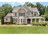 Beautiful two-story home with brick and siding exterior, manicured lawn, and inviting front porch at 135 Waterlace Way, Fayetteville, GA 30215