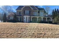 Two-story home with brick and siding, bay window, covered porch, and a well-manicured lawn at 135 Waterlace Way, Fayetteville, GA 30215