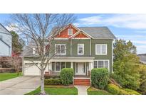 Charming two-story home with well-manicured lawn, landscaped garden, and covered porch, creating a welcoming curb appeal at 6037 Queens River Dr, Mableton, GA 30126
