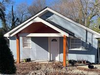 Charming bungalow-style home with light blue cinderblock exterior, a covered porch, and mature trees in the surrounding yard at 287 Henry Aaron Ave, Atlanta, GA 30310