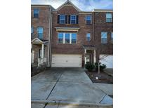Charming brick townhome with a two-car garage and a well-maintained front yard at 3765 Davis Cir, Duluth, GA 30096