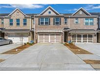 Charming brick townhome featuring a two-car garage and well-maintained landscaping at 2989 Chene Pl, Duluth, GA 30097