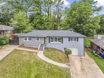 Charming single Gathering home featuring a landscaped lawn, driveway, and mature trees at 2982 Toney Dr, Decatur, GA 30032