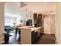 Open-concept kitchen with stainless steel appliances and breakfast bar, seamlessly connecting to the living area at 1101 Juniper Ne St # 721, Atlanta, GA 30309
