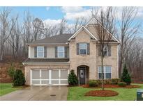 Charming two-story home with a brick facade, well-manicured lawn, and an attached two-car garage at 2890 Canter Meadow Dr, Cumming, GA 30040