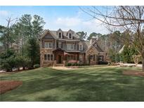 Stunning two-story home with stone and shingle exterior, complemented by a lush green lawn at 4388 Lochsa Ln, Suwanee, GA 30024