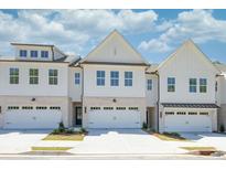 New townhome exteriors featuring white siding, brick accents, and individual one-car garages at 2407 Malster Ln, Lawrenceville, GA 30043