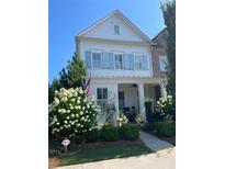 Charming two-story home with a landscaped yard, hydrangeas and a welcoming front porch at 122 Brighton Blvd, Woodstock, GA 30188