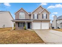 Charming two-story home featuring a brick and siding facade and an attached two-car garage at 4022 Rosebud Park Dr, Snellville, GA 30039