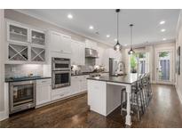 Bright, open kitchen features a large island with seating, stainless steel appliances, and wine storage at 1944 Westside Nw Blvd, Atlanta, GA 30318