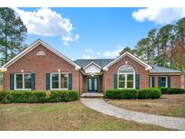 Charming brick home featuring lush landscaping, a well-manicured lawn, and a welcoming walkway to the front door at 2705 Luke Edwards Rd, Dacula, GA 30019
