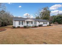 Charming single-story home featuring a classic white exterior with black shutters and well-manicured landscaping at 3005 Patten Dr, Marietta, GA 30062