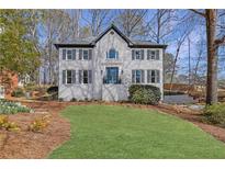 Charming two-story home featuring a well-manicured front yard and classic architectural details at 330 Highlands Trce, Roswell, GA 30075