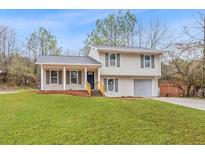Charming two-story home with a well-manicured lawn and cozy covered entryway at 5587 Saint Thomas Dr, Lithonia, GA 30058
