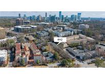 An aerial view of townhomes surrounded by trees, city skyline in the background, and easy access to nearby urban amenities at 3535 Roswell Ne Rd # H2, Atlanta, GA 30305