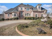 Elegant brick home with manicured landscaping, stately fountain, and a circular driveway at 461 Wynns Way, Atlanta, GA 30331