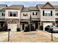 Charming townhome with a well-manicured lawn, attached garage, and inviting entryway at 567 Oakside Pl, Acworth, GA 30102