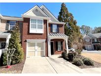 Charming brick townhome features a one-car garage, covered entry, and well-maintained landscaping at 9775 Alberton Ln, Alpharetta, GA 30022