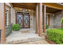 Elegant brick home entrance with custom wood doors and covered porch offers charming curb appeal at 2353 Habersham Sw Dr, Marietta, GA 30064