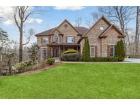 Beautiful two-story brick home with a well-manicured lawn and mature trees and shrubbery at 2353 Habersham Sw Dr, Marietta, GA 30064