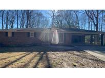 Charming single-story brick home with a covered carport and mature trees in a peaceful neighborhood at 533 Fayetteville Rd, Fairburn, GA 30213
