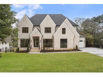 Charming two-story home with a manicured lawn, modern black window frames, and welcoming entryway at 4895 Lansbury Dr, Atlanta, GA 30342