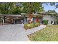 Charming single-Gathering home featuring a covered carport, stone facade and a vibrant red front door at 2837 Marlin Dr, Chamblee, GA 30341