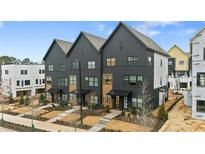 New townhomes show stylish, modern, painted brick exteriors with black trim and welcoming front entries at 656 Soul Aly, Alpharetta, GA 30009