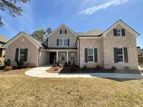 Charming brick home featuring a manicured front yard with lush landscaping and a welcoming entrance at 7260 Bluewater Ln, Douglasville, GA 30135
