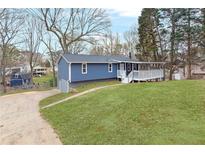 Charming blue home featuring a welcoming front porch and a well-maintained lawn at 4055 Covey Ln, Douglasville, GA 30135